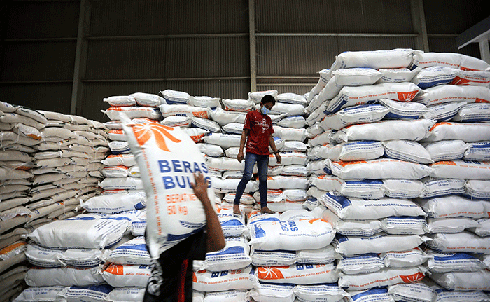 Petugas mengemas beras di gudang Bulog, Jakarta, Jumat (14/4/2023).