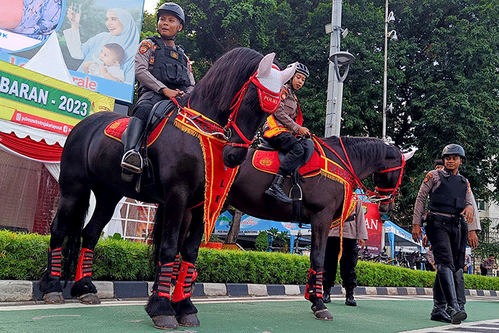 Petugas kepolisian berkuda saat patroli pengamanan di kawasan Car Free Day, Jakarta, Minggu (16/4/2023).
