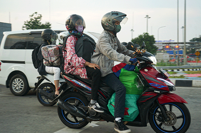 Pemudik menggunakan sepeda motor melintas di Jalan M Hasibuan, Bekasi, Jawa Barat, Selasa (18/4/2023).