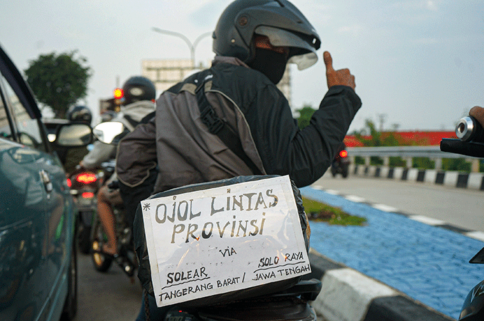 Pemudik menggunakan sepeda motor melintas di Jalan M Hasibuan, Bekasi, Jawa Barat, Selasa (18/4/2023).
