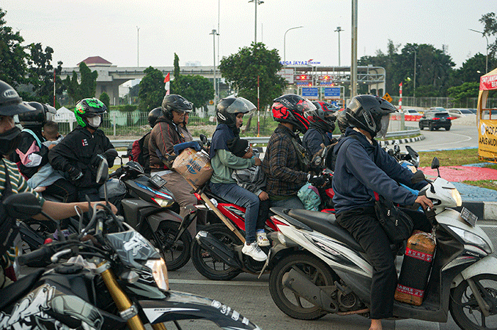 Pemudik menggunakan sepeda motor melintas di Jalan M Hasibuan, Bekasi, Jawa Barat, Selasa (18/4/2023).
