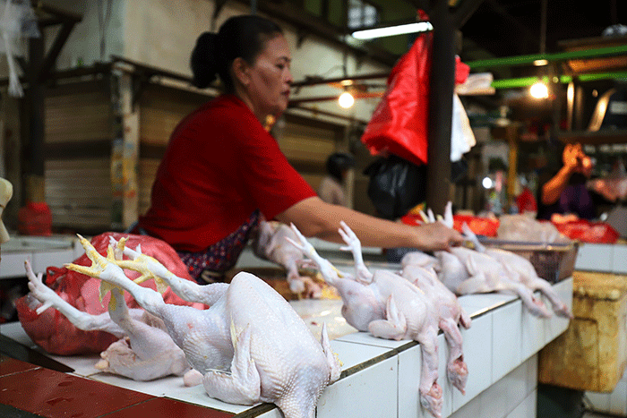 Pedagang ayam potong saat menunggu pembeli di pasar tradisional di kawasan Jakarta Selatan, Senin (17/4/2023).