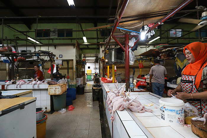 Pedagang ayam potong saat menunggu pembeli di pasar tradisional di kawasan Jakarta Selatan, Senin (17/4/2023).