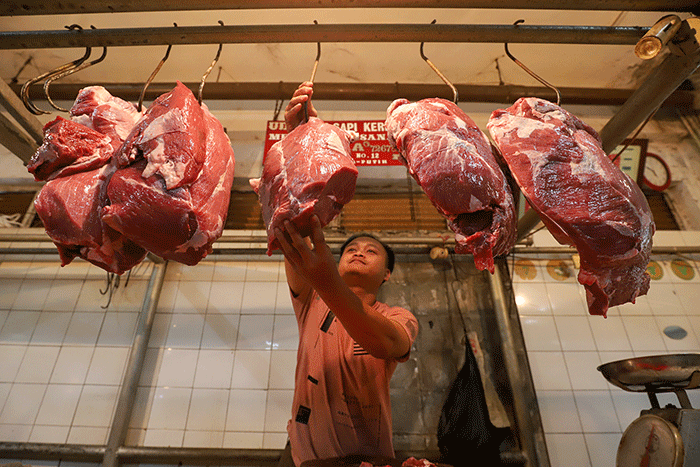 Pedagang daging sapi melayani pembeli di pasar tradisional di kawasan Jakarta Selatan, Senin (17/4/2023).