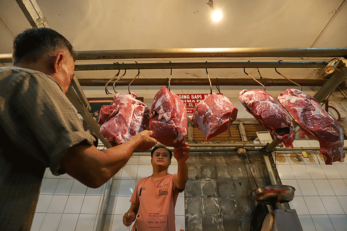 Pedagang daging sapi melayani pembeli di pasar tradisional di kawasan Jakarta Selatan, Senin (17/4/2023).
