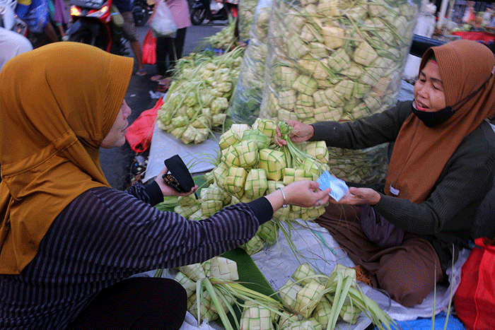 Pedagang kulit ketupat melayani pembeli di kawasan Pasar Tradisional Serdang, Jakarta, Rabu (19/4/2023).