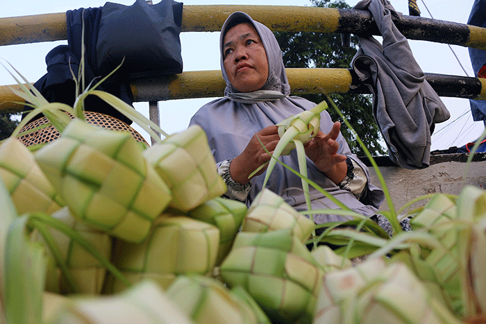 Pedagang kulit ketupat melayani pembeli di kawasan Pasar Tradisional Serdang, Jakarta, Rabu (19/4/2023).