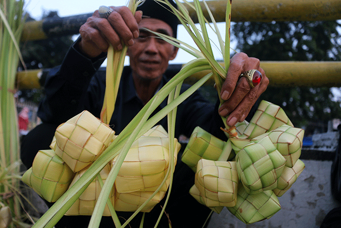 Pedagang kulit ketupat melayani pembeli di kawasan Pasar Tradisional Serdang, Jakarta, Rabu (19/4/2023).