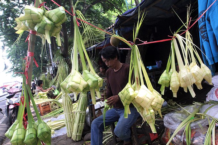 Pedagang kulit ketupat membuat ketupat di kawasan Palmerah, Jakarta, Jumat (21/4/2023).