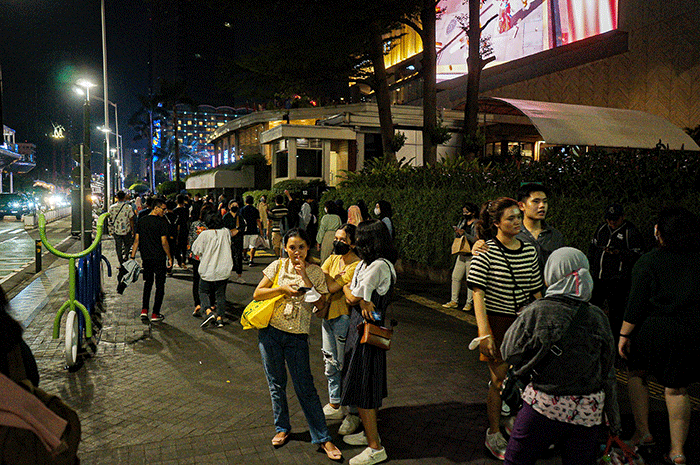 Sejumlah warga berswafoto di kawasan Bundaran HI, Jakarta, Minggu (23/4/2023).