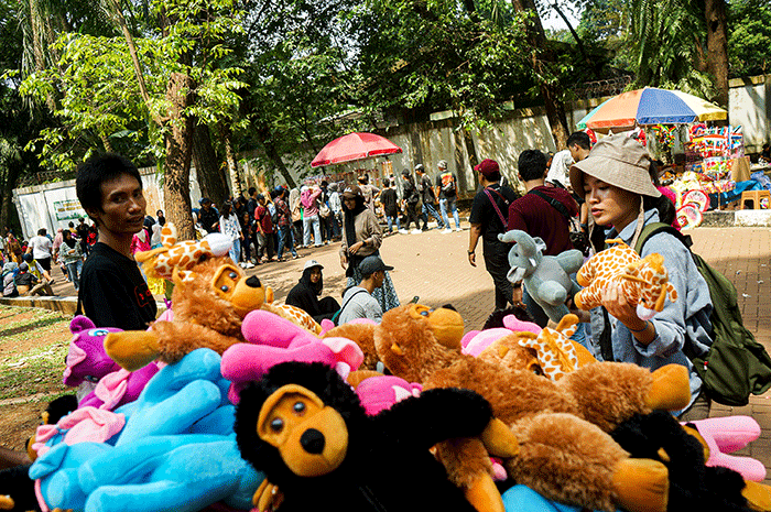 Hendra (66) salah satu penjual boneka hewan menunjukkan dagangannya di Taman Margasatwa Ragunan, Senin (24/4/2023).