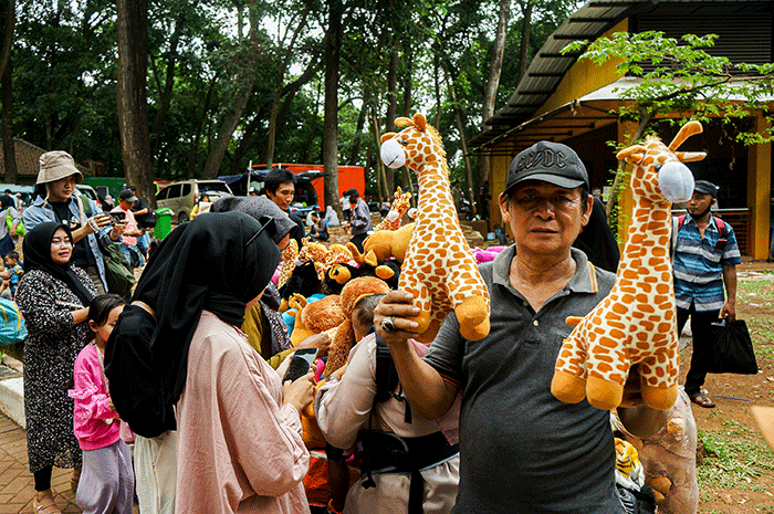 Hendra (66) salah satu penjual boneka hewan menunjukkan dagangannya di Taman Margasatwa Ragunan, Senin (24/4/2023).