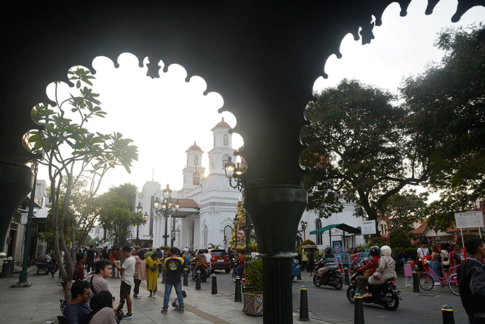 Sejumlah wisatawan berswafoto dengan latar belakang bangunan kuno dan bersejarah di kawasan Kota Lama Semarang, Jawa Tengah, Selasa (25/4/2023).