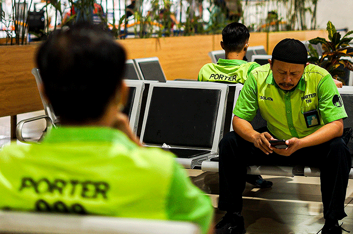 Porter saat membantu pemudik membawa barang di Stasiun Pasar Senen, Jakarta, Rabu (26/4/2023).