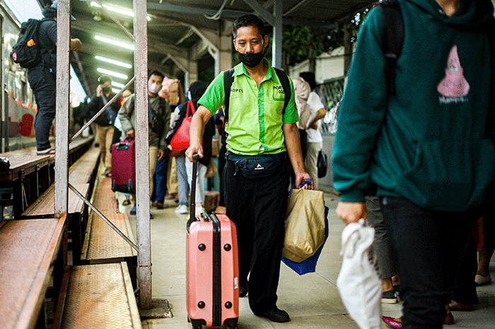 Porter saat membantu pemudik membawa barang di Stasiun Pasar Senen, Jakarta, Rabu (26/4/2023).