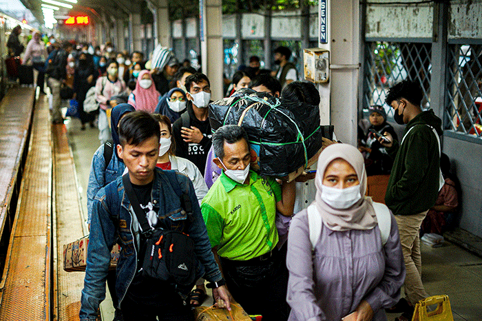 Porter saat membantu pemudik membawa barang di Stasiun Pasar Senen, Jakarta, Rabu (26/4/2023).