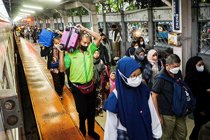Porter saat membantu pemudik membawa barang di Stasiun Pasar Senen, Jakarta, Rabu (26/4/2023).