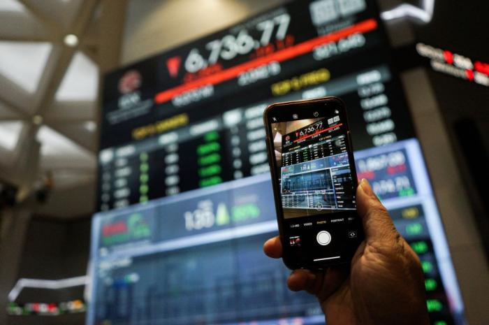 Pengunjung melihat layar pergerakan indeks harga saham gabungan (IHSG) di Gedung Bursa Efek Indonesia (BEI) Jakarta, Jumat (12/5/2023).