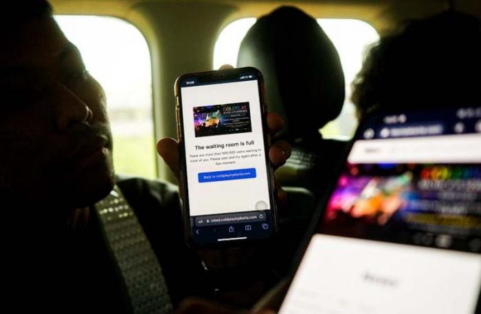 Seorang fans tengah berburu tiket nonton konser band Coldplay menggunakan ponsel melalui website resmi di Jakarta, Rabu (17/5/2023).