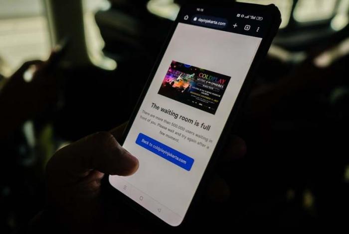 Seorang fans tengah berburu tiket nonton konser band Coldplay menggunakan ponsel melalui website resmi di Jakarta, Rabu (17/5/2023).