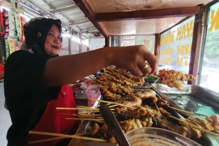 Pedagang makanan melayani pembeli di kawasan Persada Kuningan Raya, Jakarta, Sabtu (27/5/2023).