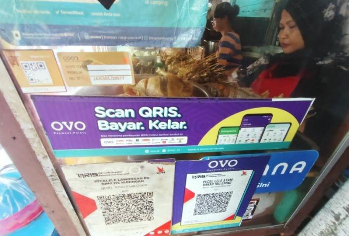 Pembeli menggunakan fitur QRIS di salah satu warung makanan di kawasan Persada Kuningan Raya, Jakarta, Sabtu (27/5/2023).
