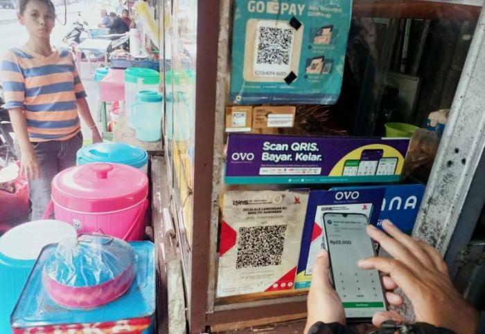 Pembeli menggunakan fitur QRIS di salah satu warung makanan di kawasan Persada Kuningan Raya, Jakarta, Sabtu (27/5/2023).