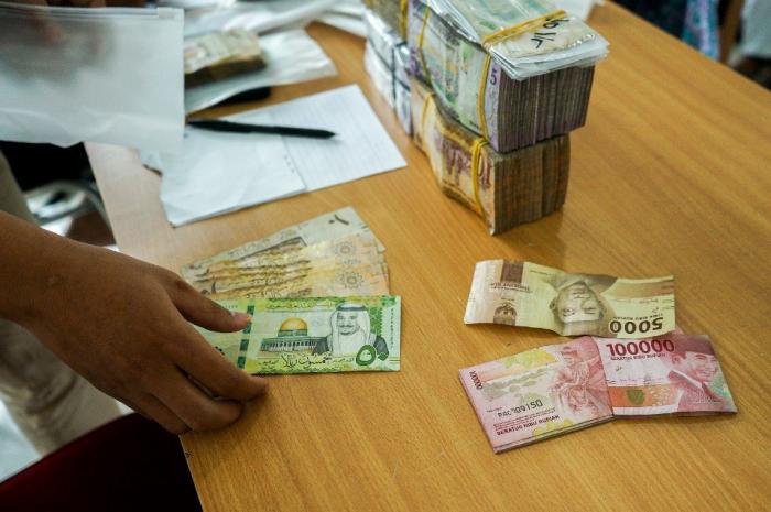 Petugas melayani penukaran mata uang Saudi Riyal untuk jamaah haji di Asrama Haji Pondok Gede, Jakarta Timur, Selasa (30/5/2023).