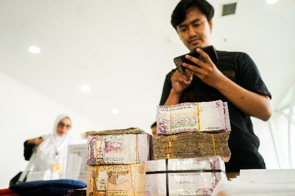 Petugas melayani penukaran mata uang Saudi Riyal untuk jamaah haji di Asrama Haji Pondok Gede, Jakarta Timur, Selasa (30/5/2023).