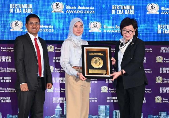 Corporate Secretary SIG Vita Mahreyni (tengah) menerima penghargaan dari Komisaris Bisnis Indonesia Dorothea Samola (kanan).