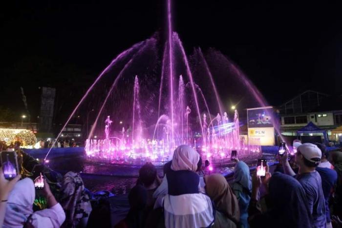 Warga menikmati warna-warni cahaya di area Makassar Light Festival Lapangan Hasanuddin, Makassar, Sulawesi Selatan, Minggu (11/6/2023).