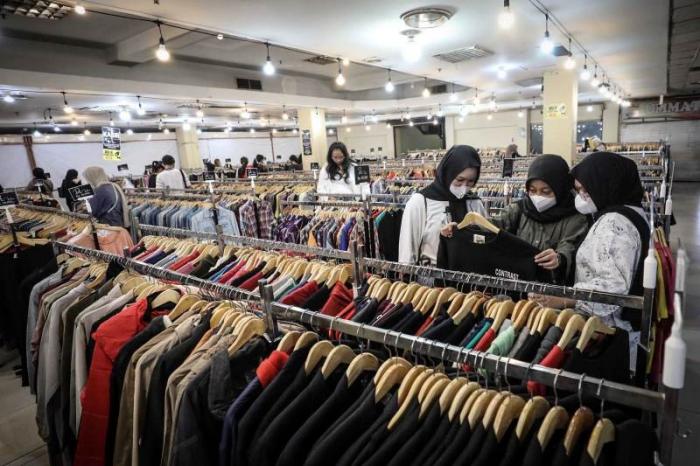 Calon pembeli memilih pakaian di salah satu gerai pakaian impor bekas di Jakarta, Senin (26/6/2023).