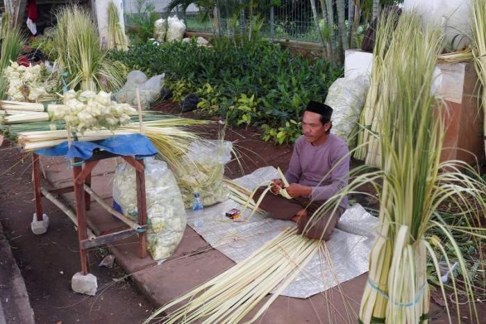 Pedagang membuat kulit ketupat untuk dijual di kawasan Jakarta Selatan, Rabu (28/6/2023).