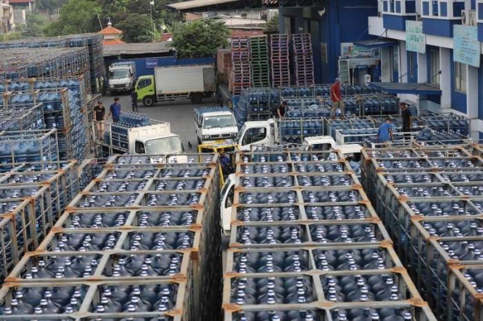 Pekerja melakukan bongkar muat air minum dalam kemasan di Jakarta, Jumat (30/6/2023).