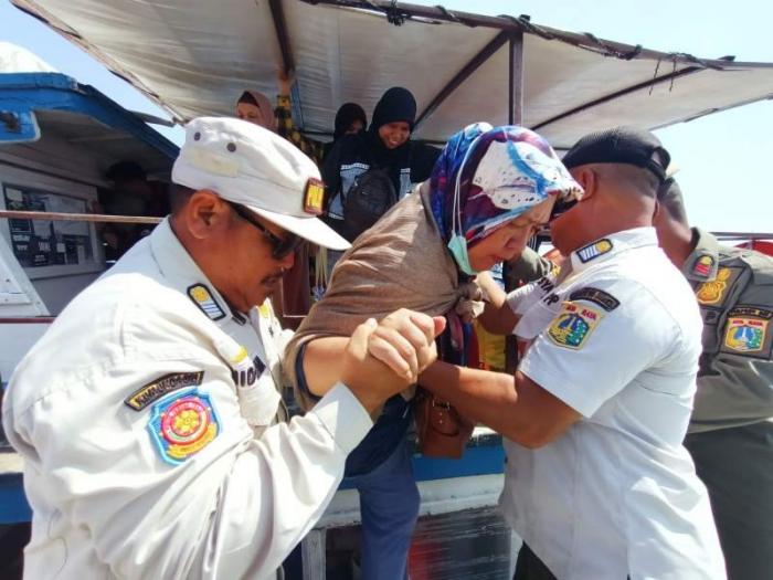 Wisatawan turun dari kapal penyeberangan tradisional di Pelabuhan Pulau Pramuka, Kabupaten Kepulauan Seribu, Provinsi DKI Jakarta, Jumat (30/6/2023).