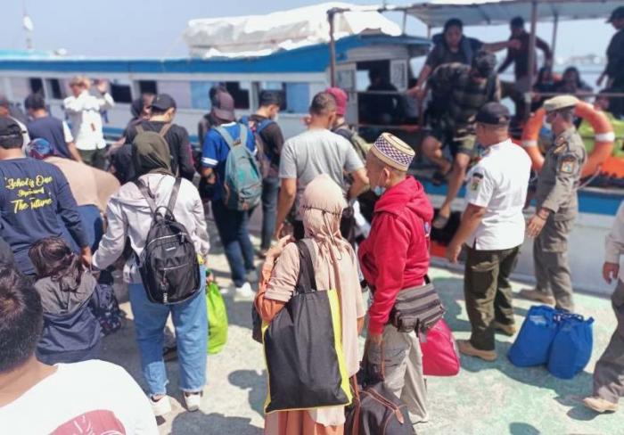 Wisatawan turun dari kapal penyeberangan tradisional di Pelabuhan Pulau Pramuka, Kabupaten Kepulauan Seribu, Provinsi DKI Jakarta, Jumat (30/6/2023).