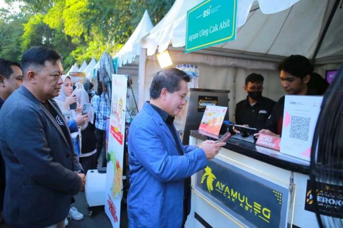 Direktur Utama BSI Hery Gunardi bertransaksi menggunakan QRIS saat berbelanja produk UMKM rekanan BSI Area Malang