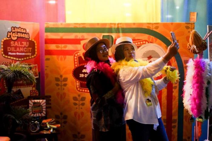 Sejumlah pengunjung berfoto di photobooth acara Lintas Melawai yang digelar di Mal Blok M, Jakarta Selatan, Jumat (28/7/2023).