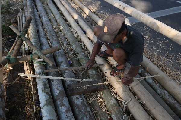 Pedagang membuat tiang panjat pinang dari batang pohon pinang di kawasan Manggarai, Jakarta, Sabtu (12/8/2023).