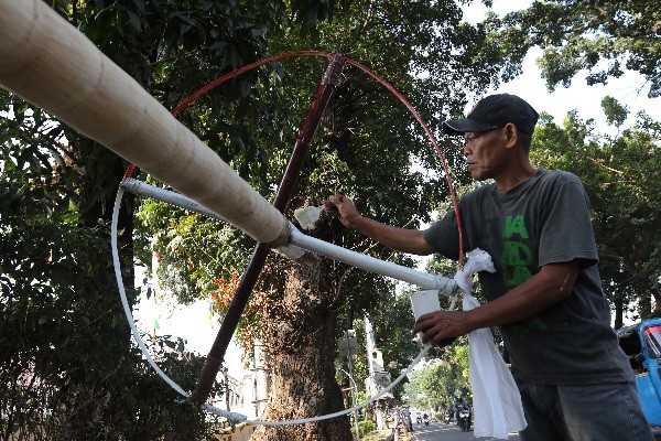 Pedagang membuat tiang panjat pinang dari batang pohon pinang di kawasan Manggarai, Jakarta, Sabtu (12/8/2023).