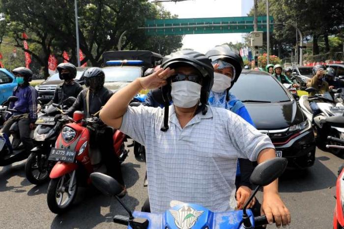 Sejumlah pengendara berhenti dan mengheningkan cipta untuk mengenang dan mendoakan para pahlawan yang telah merebut kemerdekaan Indonesia.