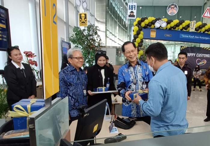Presiden Direktur BCA Jahja Setiaatmadja menyerahkan cenderamata kepada nasabah di BCA KCU City Tower, Jakarta, Senin (4/9/2023).