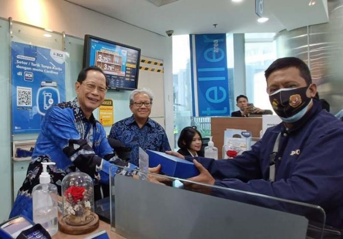 Presiden Direktur BCA Jahja Setiaatmadja menyerahkan cenderamata kepada nasabah di BCA KCU City Tower, Jakarta, Senin (4/9/2023).