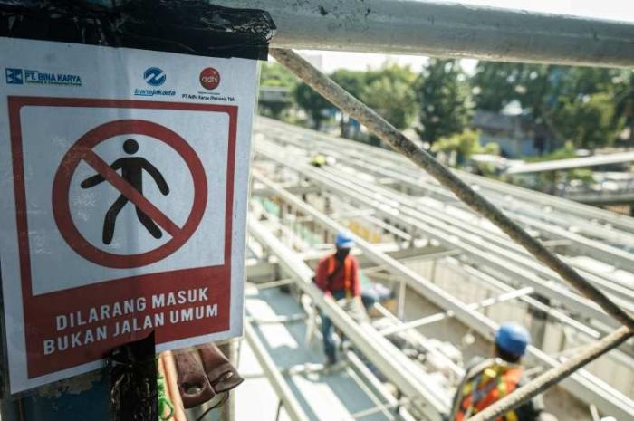 Pekerja beraktivitas di proyek revitalisasi Halte Transjakarta Cawang UKI, Jakarta, Minggu (28/9/2023).