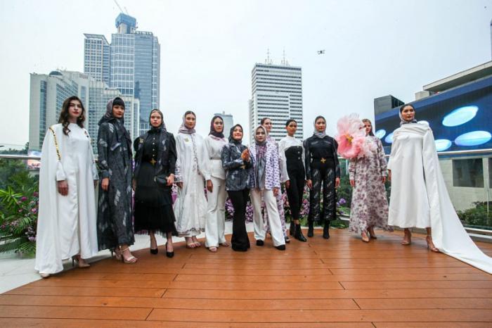 Model memperagakan busana batik karya kolaborasi Batik Trusmi X La Sabelle di Halte TransJakarta Tosari, Jakarta, Senin (2/10/2023).