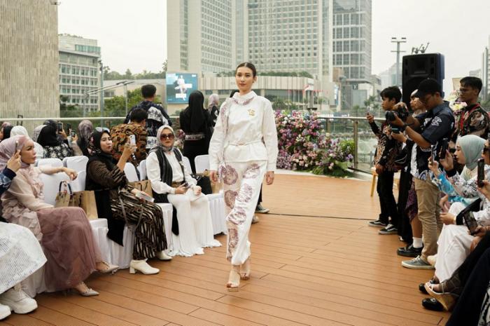 Model memperagakan busana batik karya kolaborasi Batik Trusmi X La Sabelle di Halte TransJakarta Tosari, Jakarta, Senin (2/10/2023).