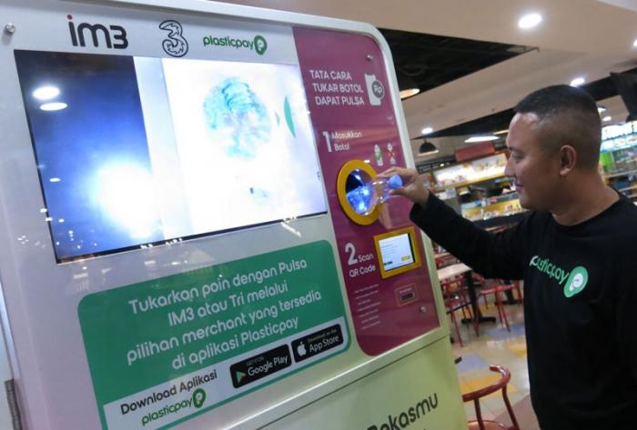Pengunjung menukarkan sampah plastik dengan pulsa dari operator seluler IM3 dan Tri melalui Reverse Vending Machine (RVM) Plasticpay, di Bogor Trade Mall (BTM)
