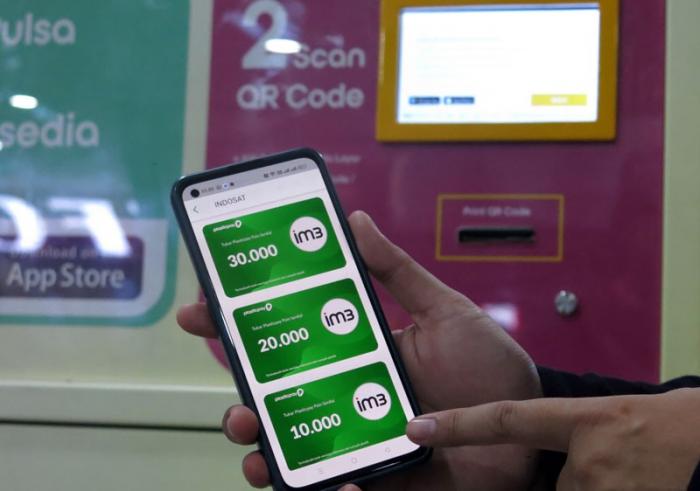 Pengunjung menukarkan sampah plastik dengan pulsa dari operator seluler IM3 dan Tri melalui Reverse Vending Machine (RVM) Plasticpay, di Bogor Trade Mall (BTM)