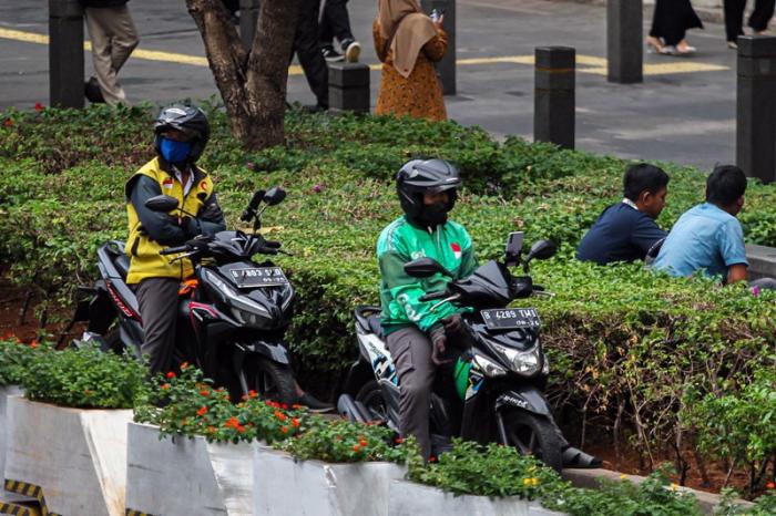 Pengendara ojek online melintas di kawasan Sudirman, Jakarta, Senin (23/10/2023).