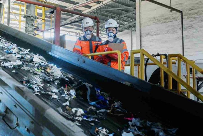 Karyawan SIG melakukan pengecekan material (Refused-Derived Fuel) yang akan dicacah untuk dimanfaatkan menjadi bahan bakar alternatif.
